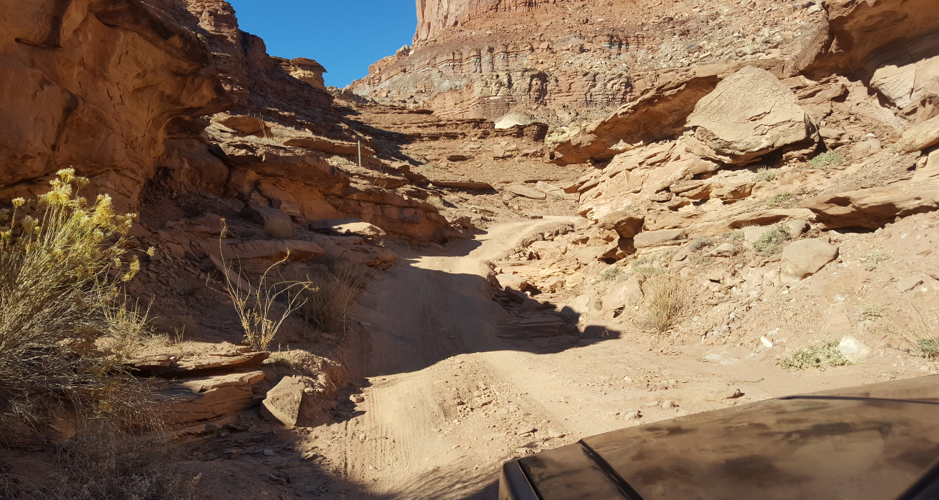 jeep climbing hill through canyon