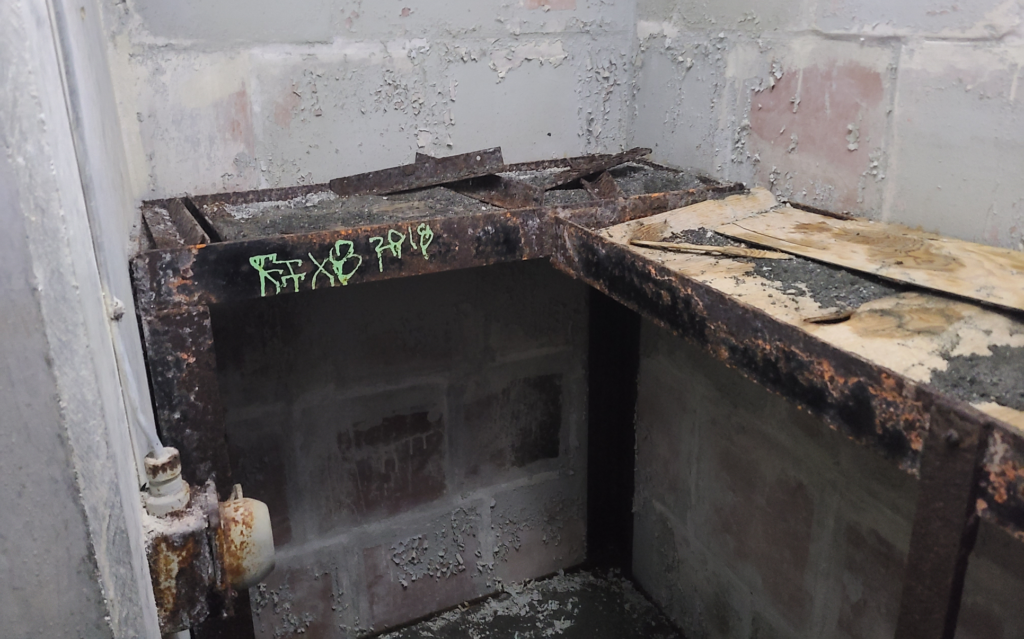 grimy storage closet with rusty metal shelves