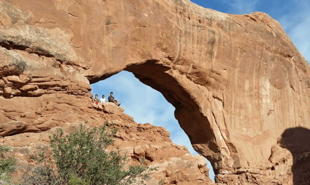 sitting in the middle of a huge red rock arch
