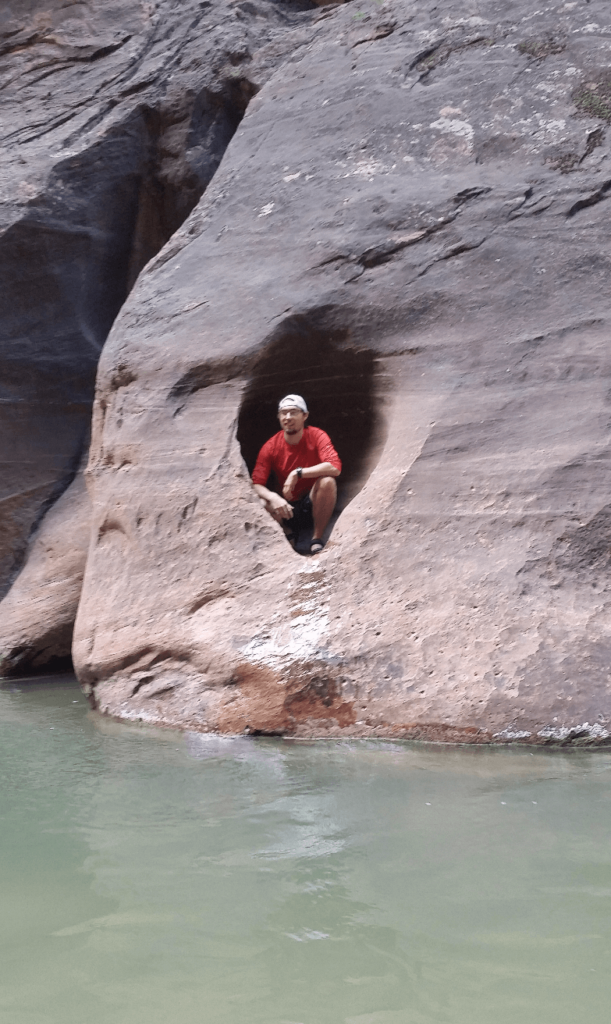 mike in a sandstone alcove above water