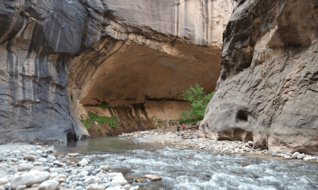 joseph and mike under a huge overhang in the canyon bend