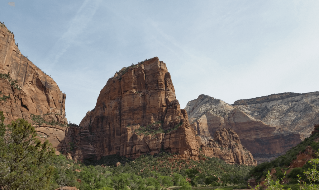 tall red sandstone spire in the middle of a canyon