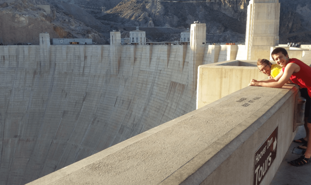 mike and joseph looking out over a giant concrete dam from the top