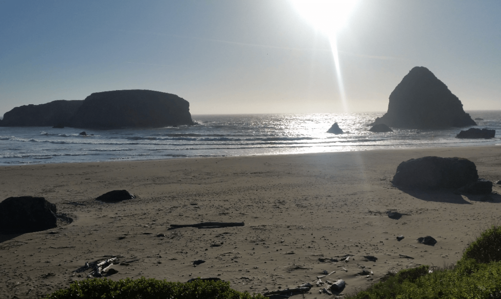 beach, crashing ocean, and seamounts with the sun low in the sky behind us